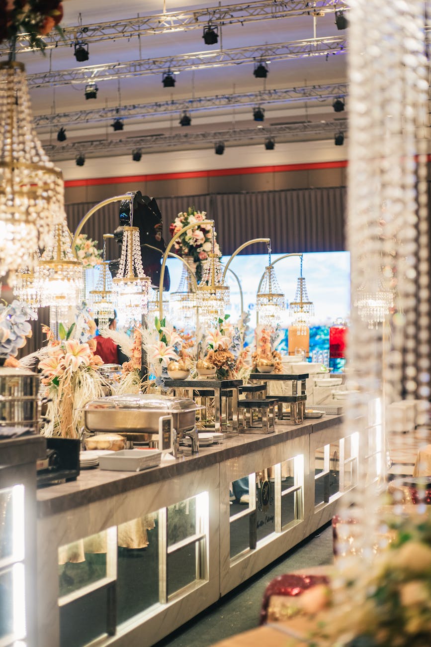 Luxurious buffet setup with chandeliers and floral decor creates a glamorous event atmosphere.