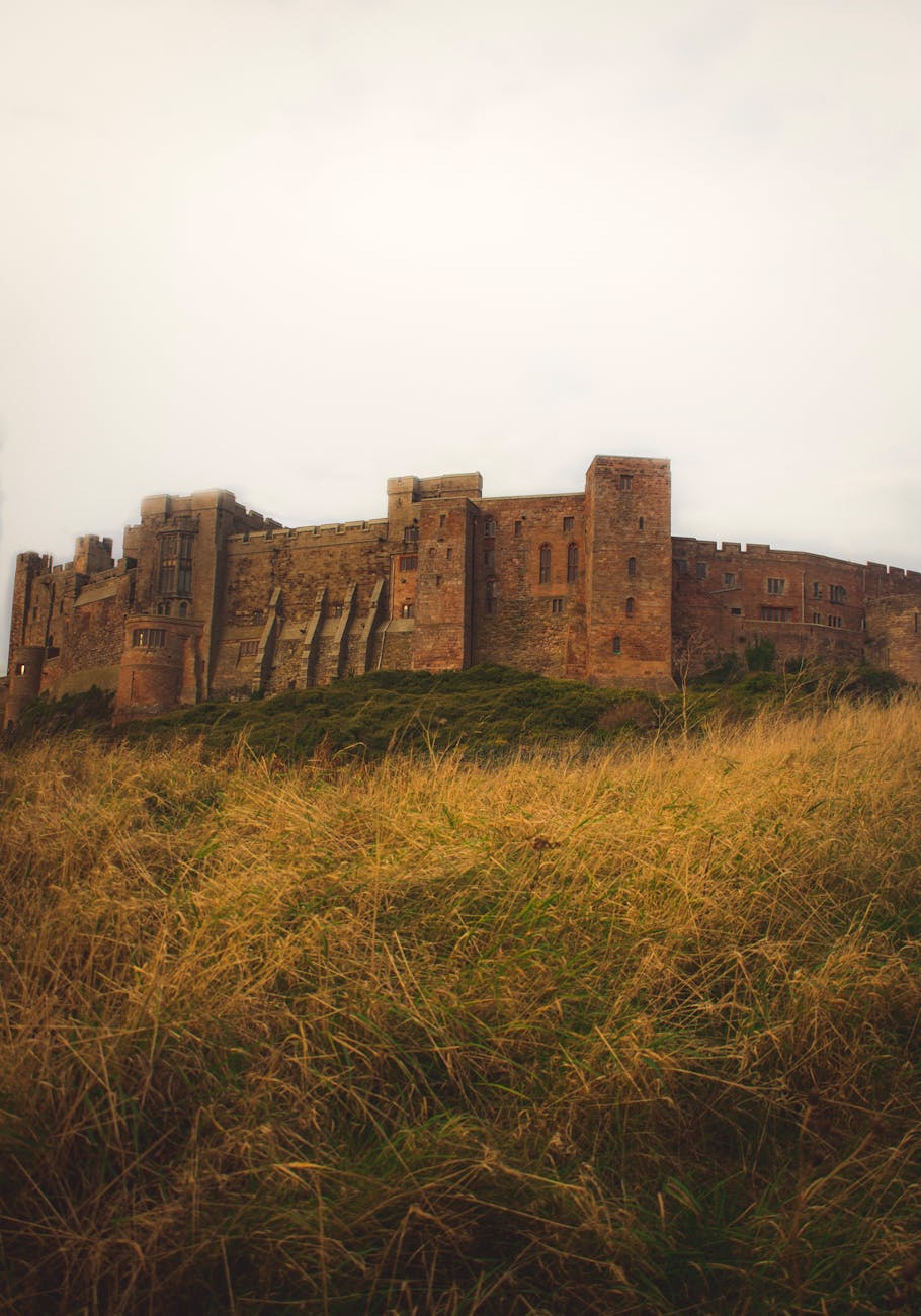 Explore the historic Bamburgh Castle in England, surrounded by lush grass.