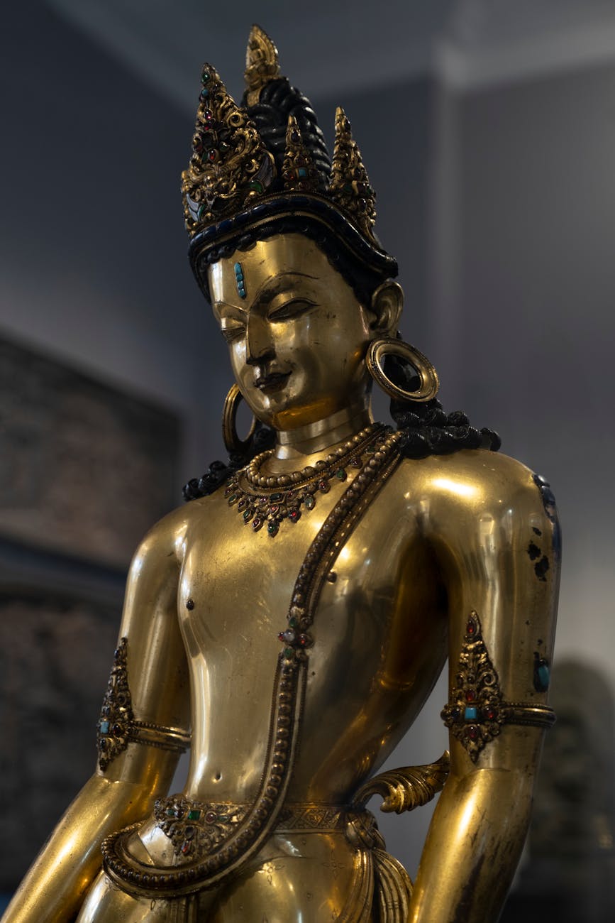 A detailed golden Buddhist statue with intricate designs in a London museum.