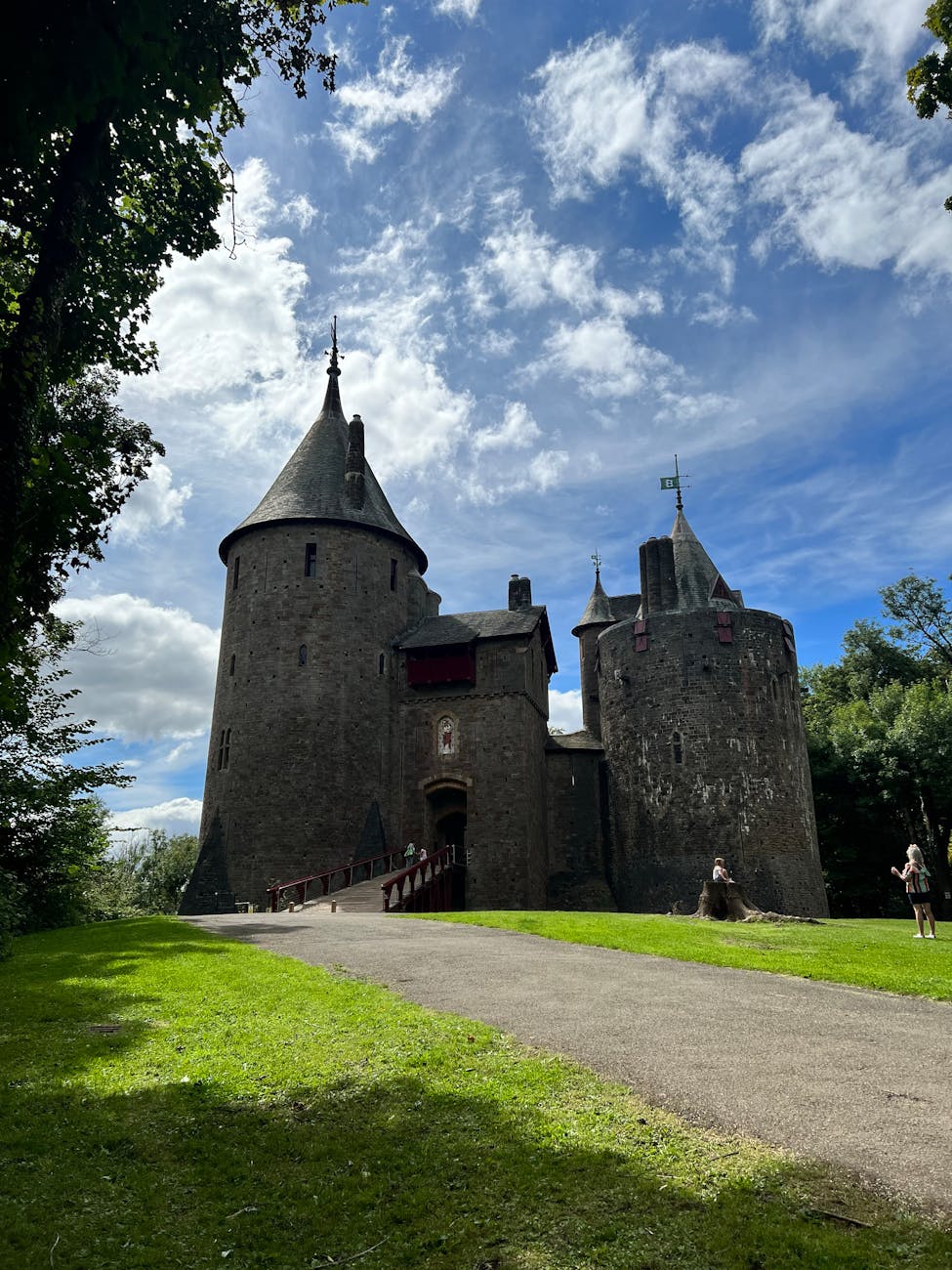 Majestic Gothic-style Castell Coch with stone towers under a vibrant sky in Wales.