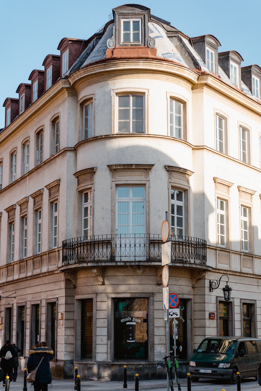Elegant historic building on a sunlit street corner, showcasing classic European architecture.