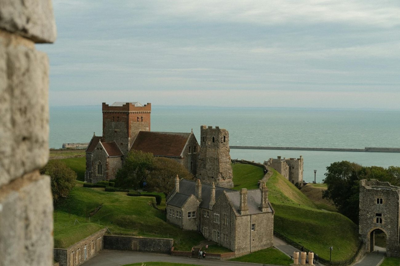 Historic Dover Castle in England with a sea backdrop, showcasing medieval architecture.