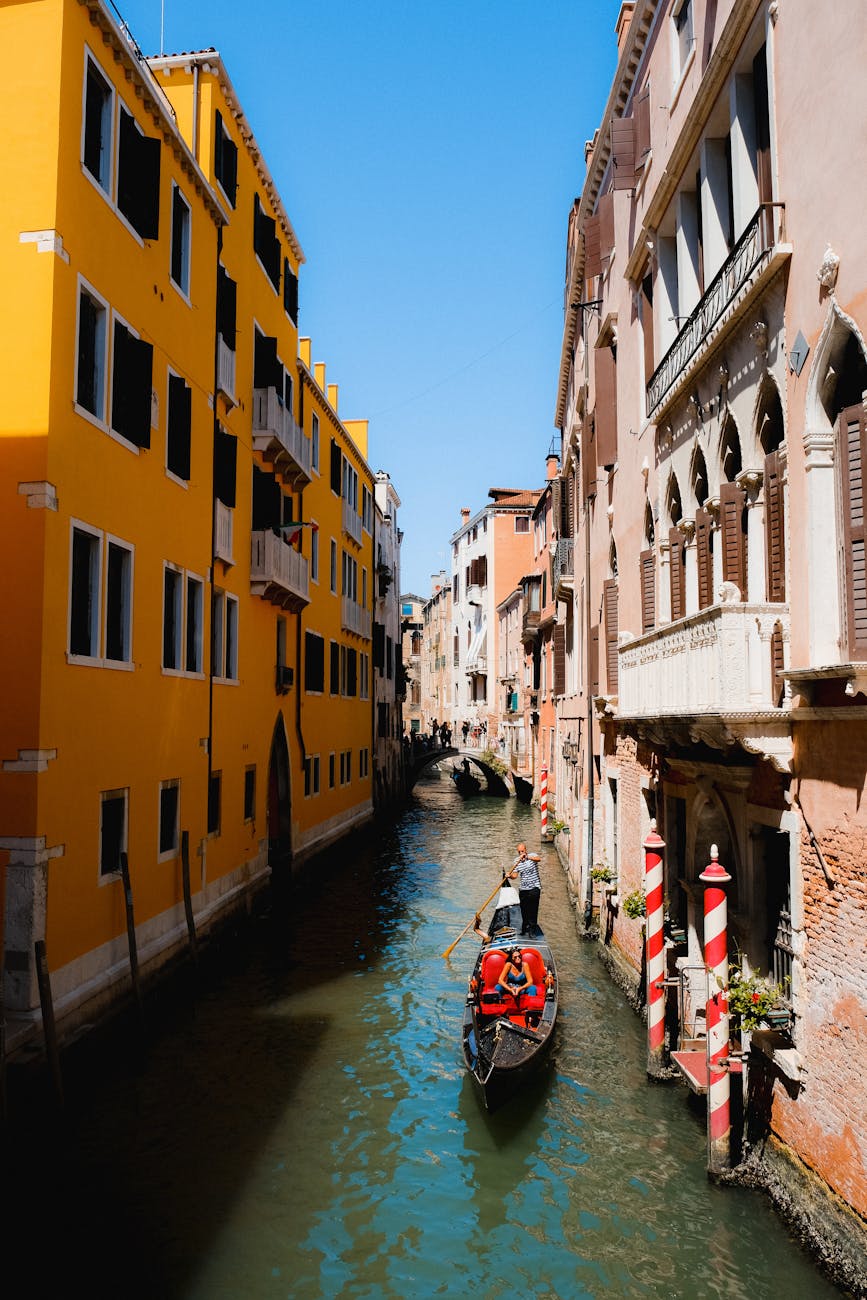 Experience a serene gondola ride through the narrow canals of Venice against colorful buildings.