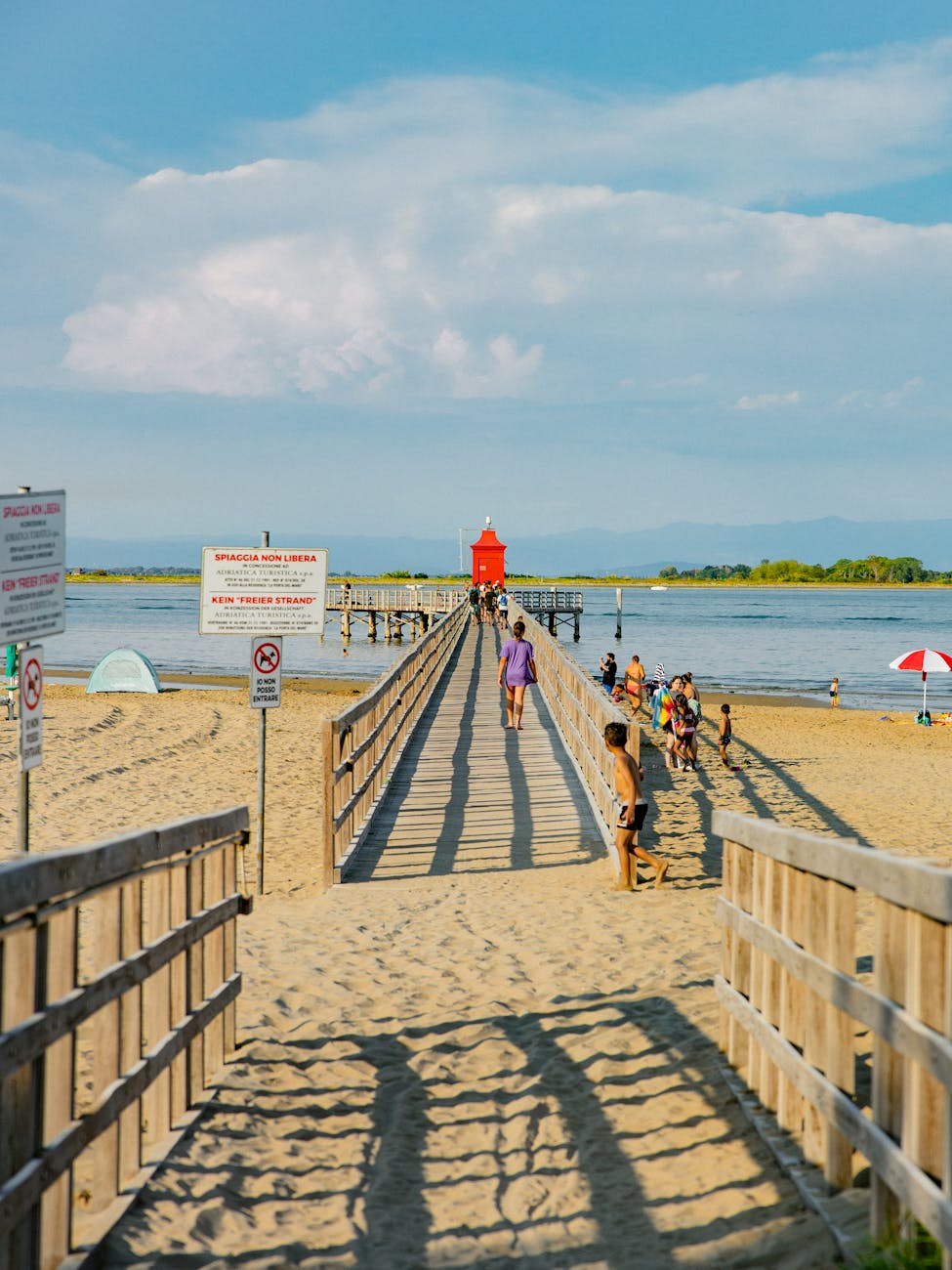 A vibrant beach boardwalk scene with people, perfect for summer travel vibes.