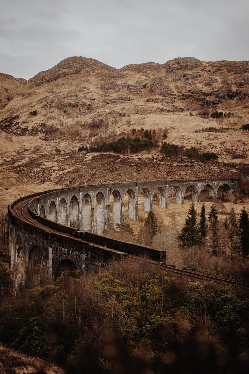 Stunning view of the Glenfinnan Viaduct amid the autumn landscape in Scotland. Perfect for travel and nature enthusiasts.
