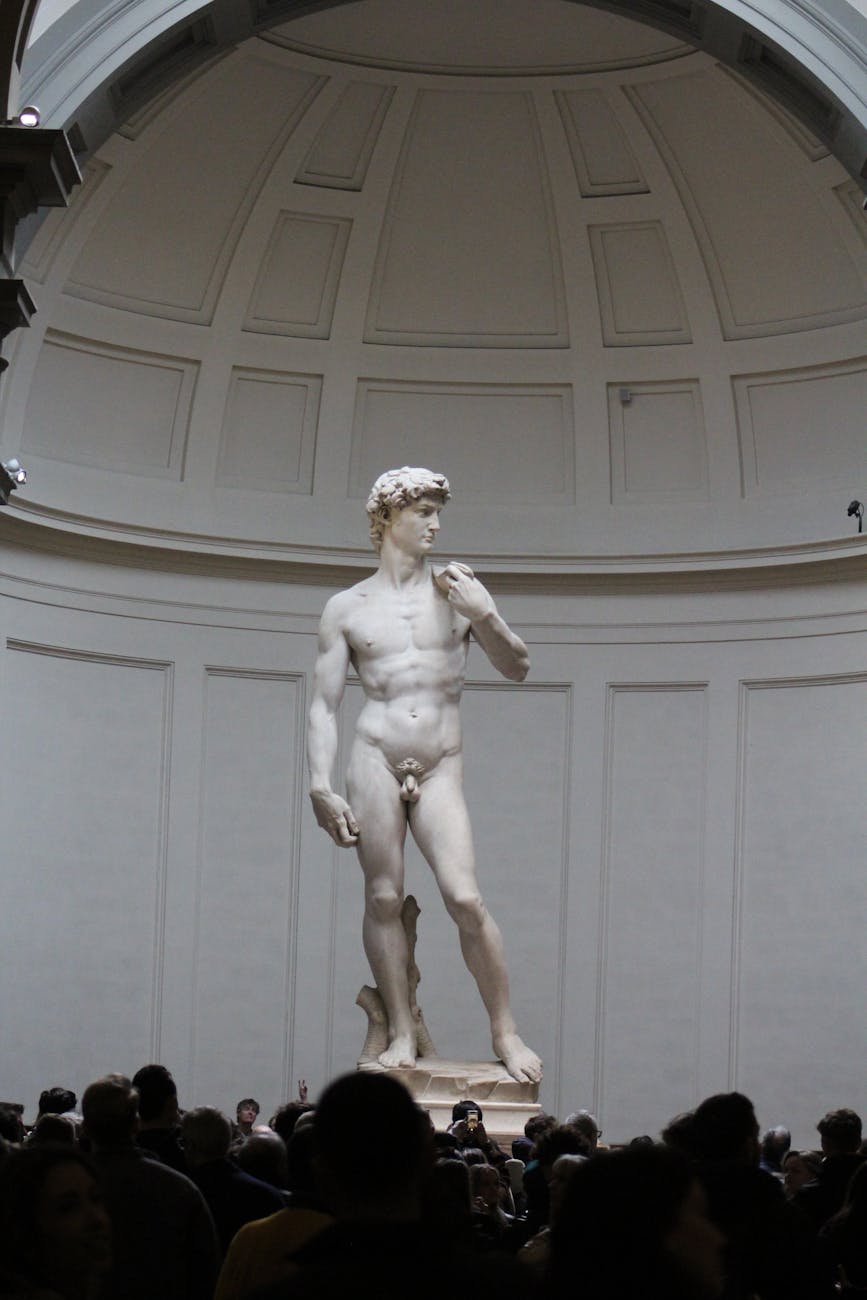 The iconic David statue by Michelangelo surrounded by visitors in Florence, Italy.